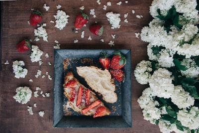 草莓三明治放在白花旁边的白色盘子里